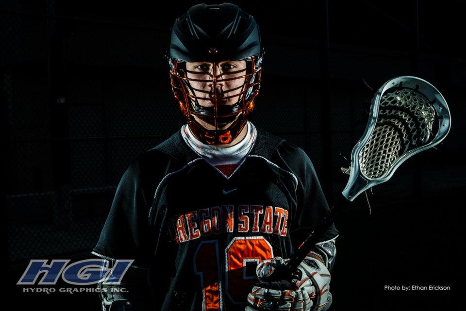 Oregon State LAX helmets featuring a black HydroSkin® shell and orange HydroChrome™ mask.